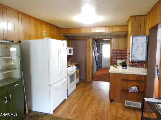kitchen featuring white appliances, wood walls, light wood-type flooring, light countertops, and brown cabinets