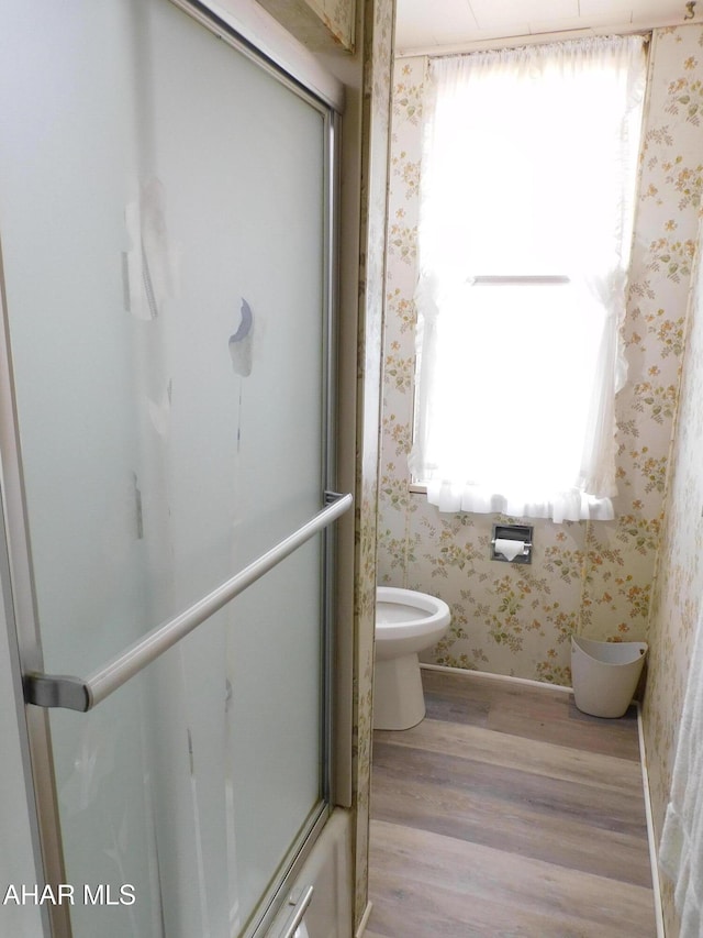 bathroom featuring wallpapered walls, wood finished floors, toilet, and baseboards