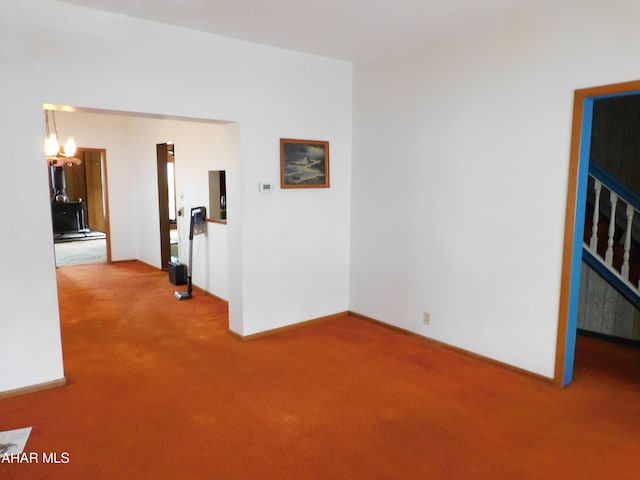 unfurnished room featuring carpet floors and a chandelier