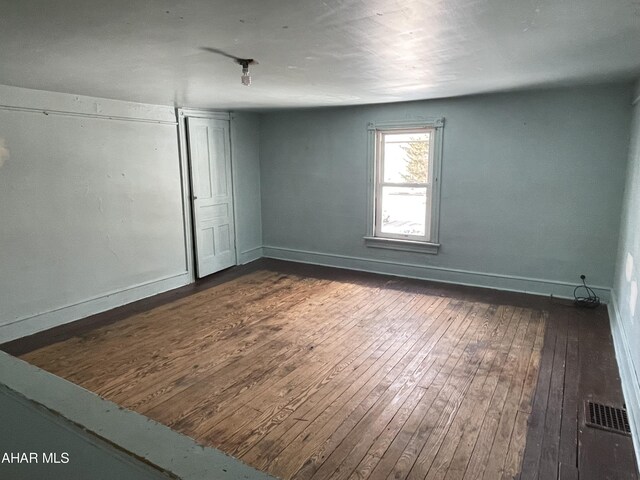 empty room with dark wood-type flooring