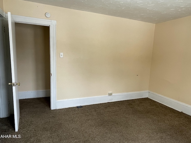 carpeted empty room with a textured ceiling