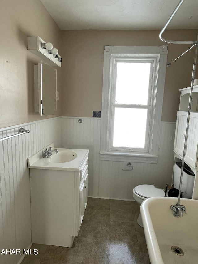 bathroom featuring a bathing tub, vanity, and toilet