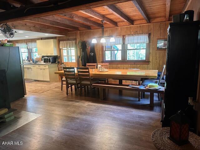 5168 Black Log Rd, Orbisonia, PA 17243 - dining room with beamed ceiling, wooden walls, light wood finished floors, and wooden ceiling