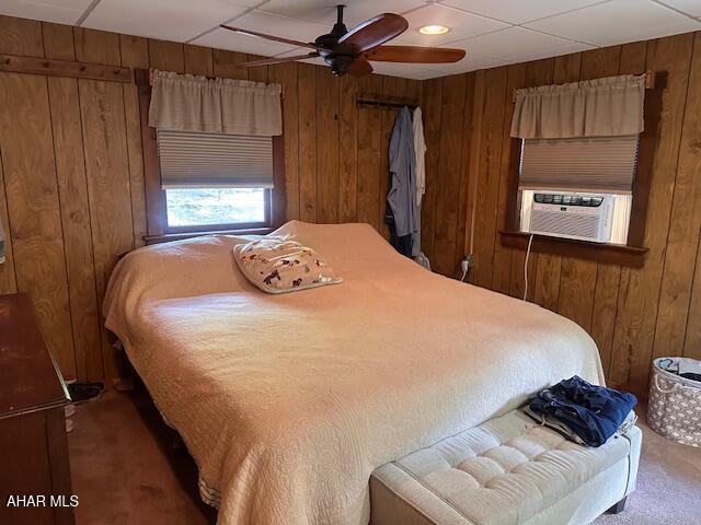 5168 Black Log Rd, Orbisonia, PA 17243 - carpeted bedroom featuring cooling unit, wood walls, ceiling fan, and a paneled ceiling