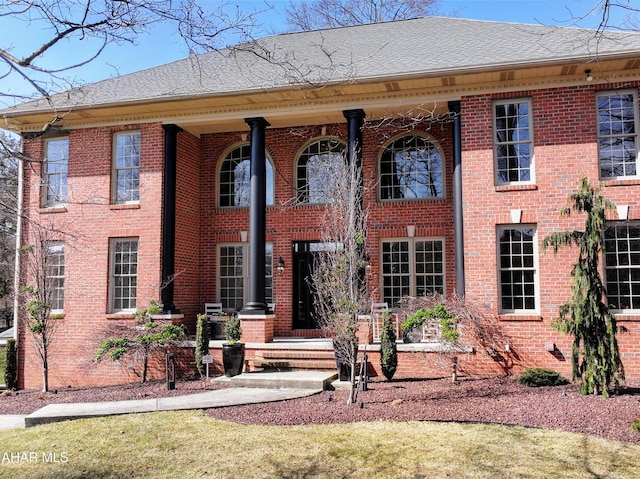 view of front of property featuring brick siding and a shingled roof