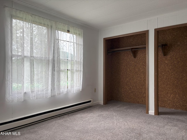 130 E 7th St, Coudersport, PA 16915 - unfurnished bedroom featuring a baseboard heating unit, carpet flooring, two closets, and crown molding