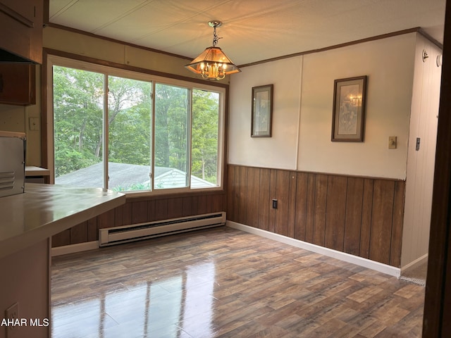 130 E 7th St, Coudersport, PA 16915 - unfurnished dining area featuring a baseboard radiator, a chandelier, wood finished floors, wainscoting, and crown molding