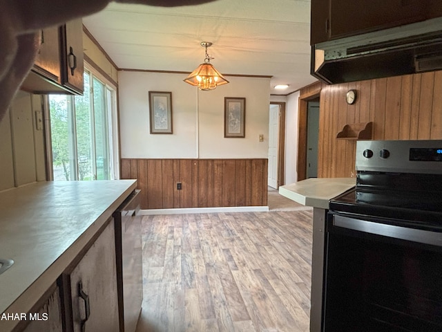 130 E 7th St, Coudersport, PA 16915 - kitchen featuring black electric range oven, wood walls, exhaust hood, light wood-style floors, and a wainscoted wall