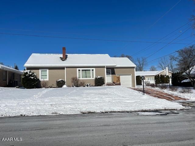 view of front of home with a garage and central AC