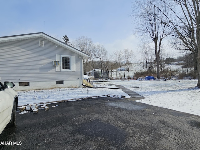 view of snowy exterior with a wall mounted AC