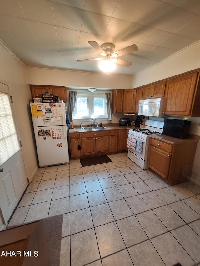 kitchen featuring ceiling fan, sink, white appliances, light tile patterned floors, and ornamental molding