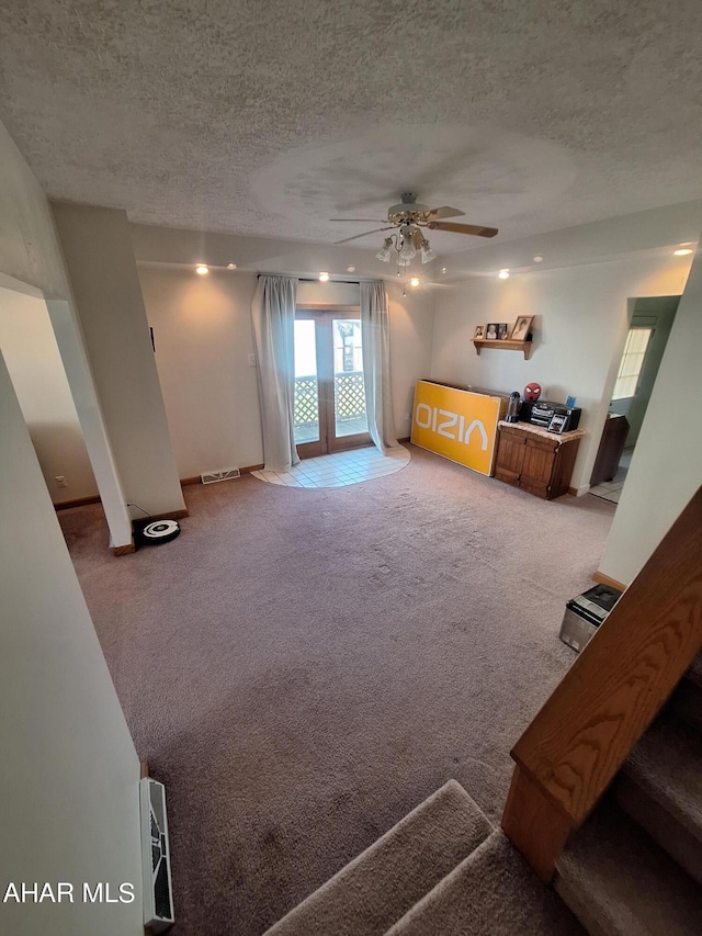 carpeted living room featuring a textured ceiling and ceiling fan