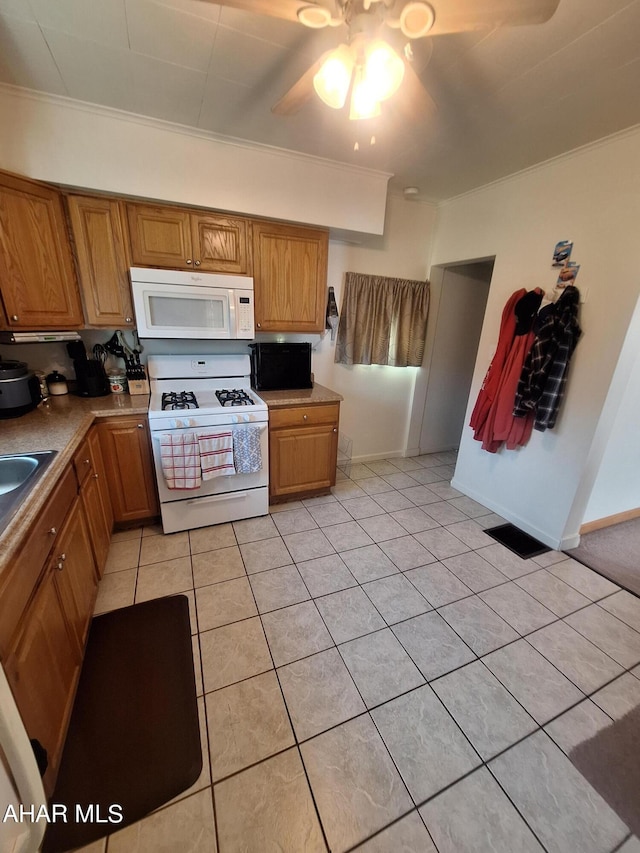 kitchen with white appliances, ceiling fan, crown molding, and light tile patterned flooring