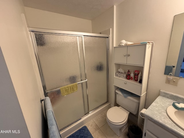 bathroom with toilet, vanity, tile patterned floors, and walk in shower