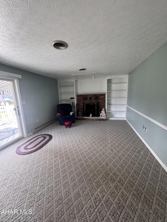 unfurnished living room with carpet flooring, a baseboard radiator, a textured ceiling, and a brick fireplace