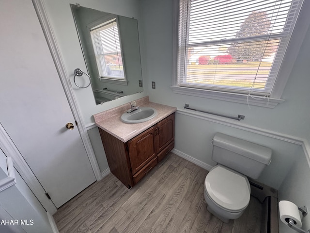 bathroom featuring wood-type flooring, vanity, toilet, and plenty of natural light