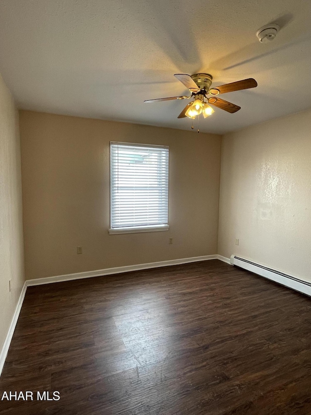 unfurnished room with ceiling fan, dark hardwood / wood-style flooring, and a baseboard heating unit