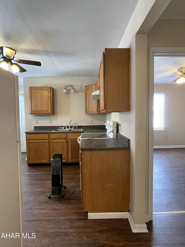 kitchen featuring range, a textured ceiling, dark hardwood / wood-style floors, and sink