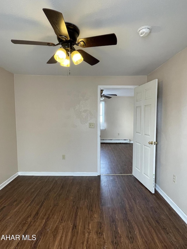 spare room featuring ceiling fan, dark wood-type flooring, and a baseboard radiator