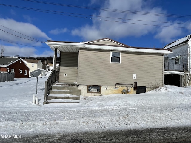 view of snow covered back of property