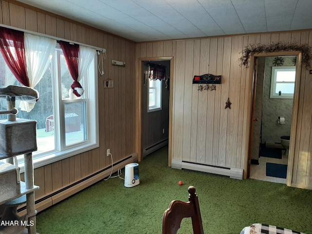 interior space with carpet floors, wooden walls, and baseboard heating