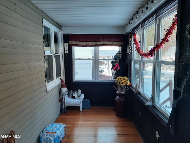 sunroom / solarium featuring rail lighting