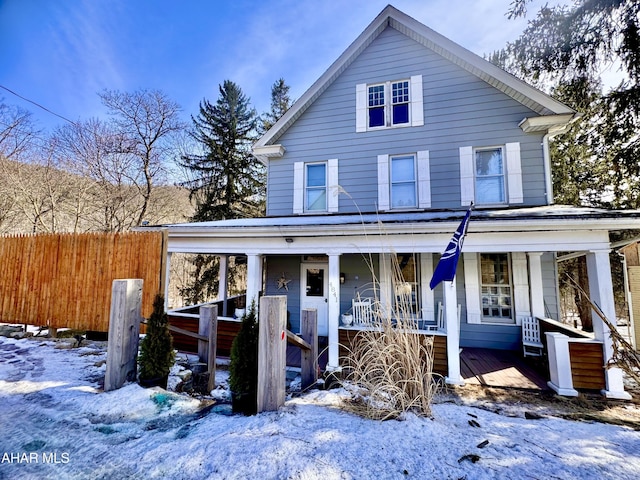 view of front of home featuring covered porch and fence