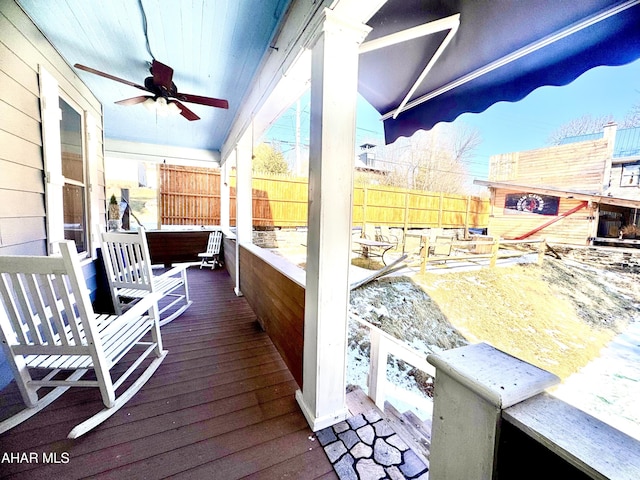 wooden deck with ceiling fan and a fenced backyard