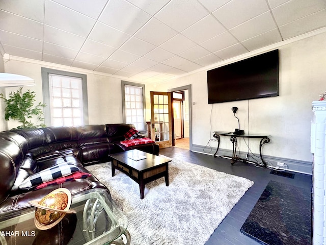 living area featuring crown molding and baseboards