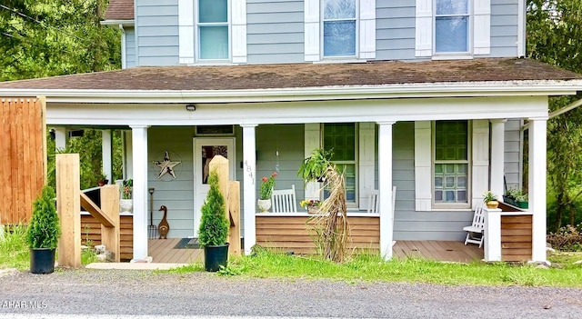 exterior space featuring a porch and roof with shingles