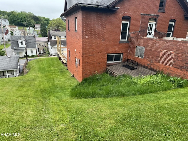 321 Main St, Gallitzin, PA 16641 - view of property exterior featuring a yard, brick siding, a residential view, and a patio area