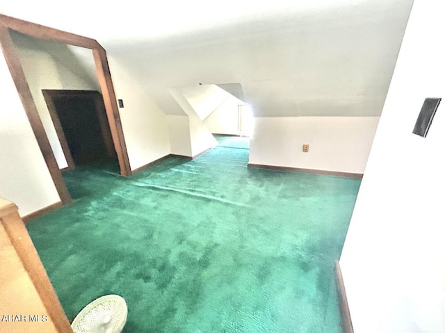 bonus room featuring dark colored carpet and lofted ceiling