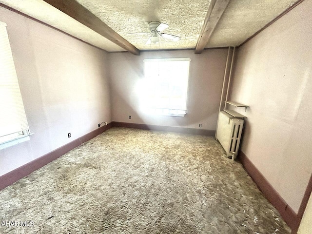 carpeted empty room featuring beamed ceiling, a textured ceiling, radiator, and ceiling fan