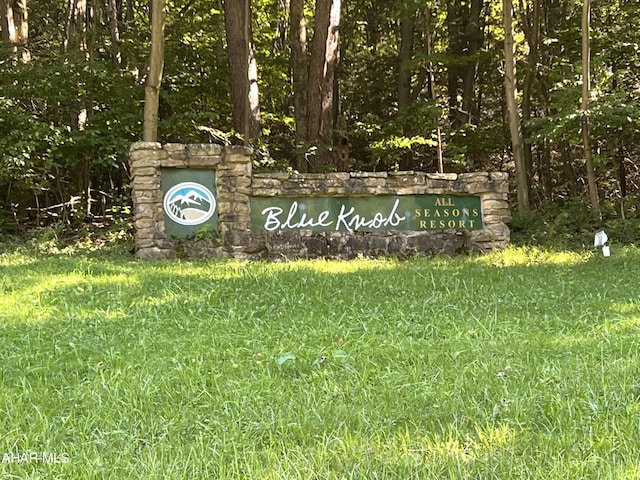 community / neighborhood sign featuring a yard