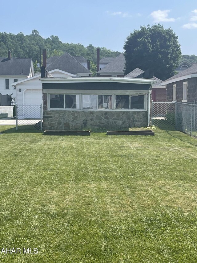 523 W 16th St, Tyrone, PA 16686 - view of front of house featuring stone siding, a sunroom, and a garage
