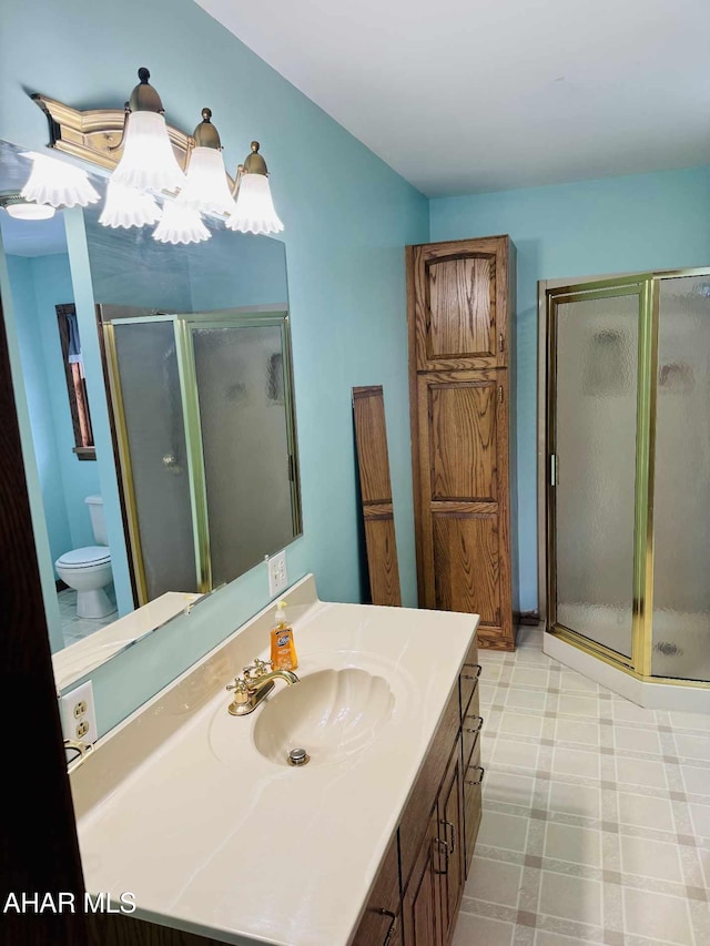 bathroom featuring a chandelier, vanity, toilet, and a shower with shower door