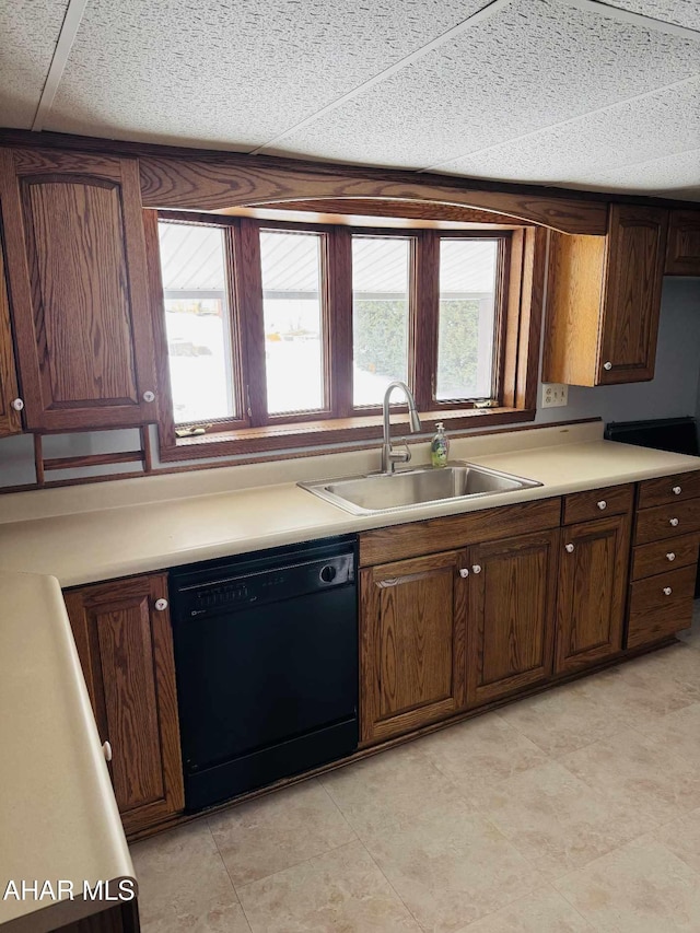 kitchen featuring dark brown cabinetry, sink, and black dishwasher