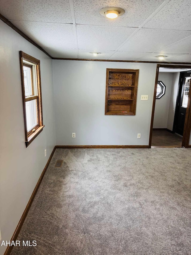 empty room with a paneled ceiling and carpet floors