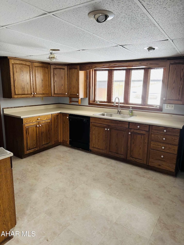 kitchen with a paneled ceiling, black dishwasher, and sink