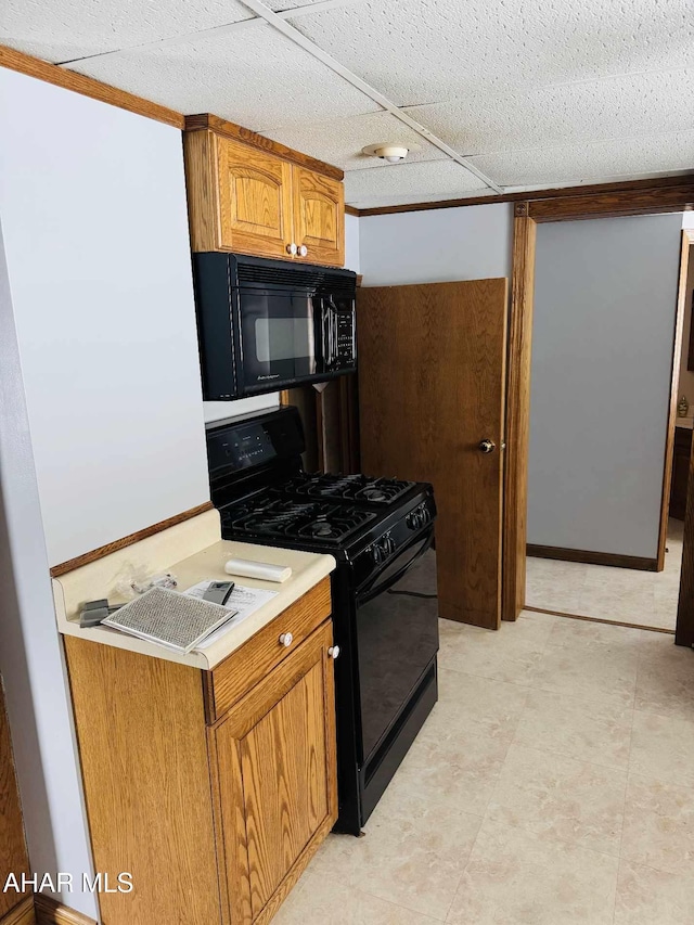 kitchen featuring a paneled ceiling and black appliances