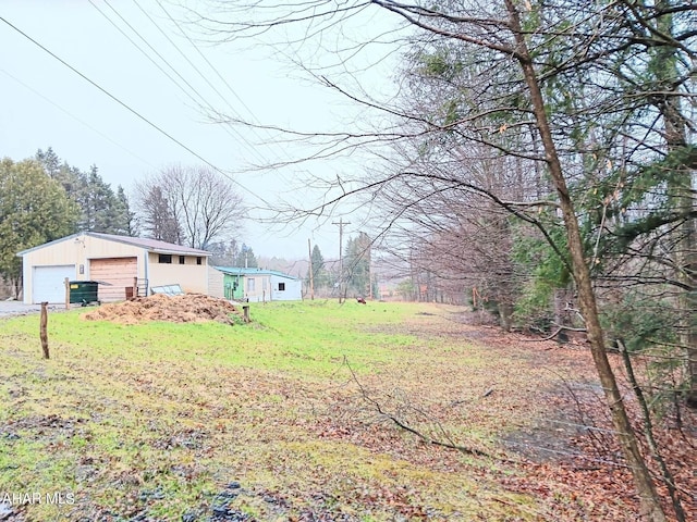 view of yard with an outbuilding, a garage, and central AC unit