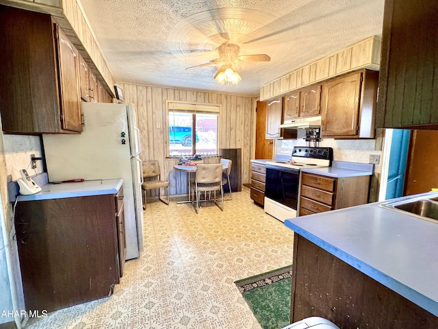 kitchen with ceiling fan, under cabinet range hood, light floors, electric stove, and a textured ceiling