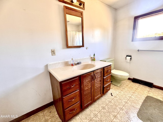 bathroom featuring tile patterned floors, baseboards, toilet, and vanity