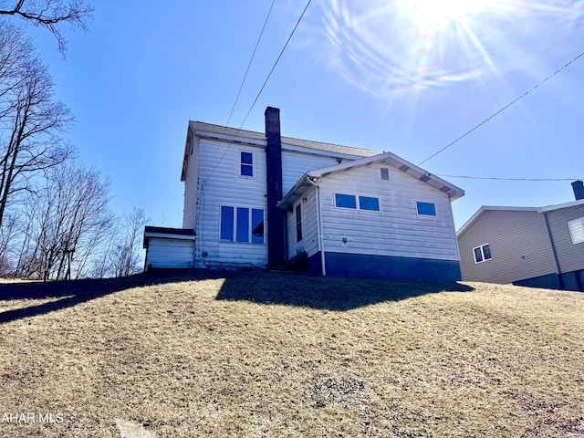 rear view of house featuring a chimney