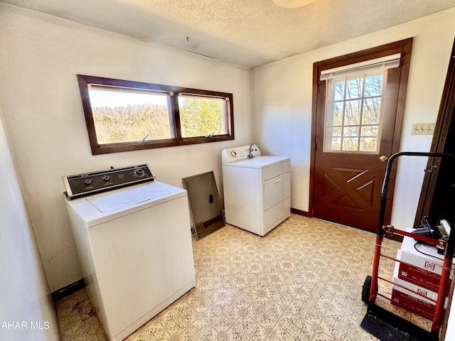 laundry room featuring laundry area, plenty of natural light, light floors, and washer and clothes dryer