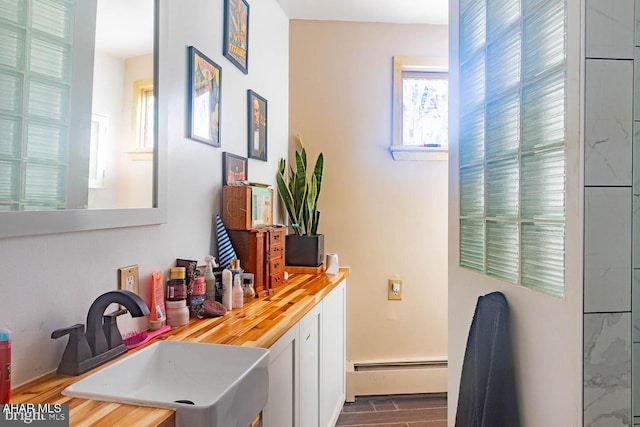 bar featuring sink, dark hardwood / wood-style floors, a baseboard radiator, and wooden counters