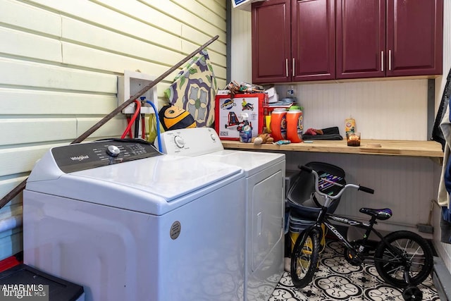 laundry area with separate washer and dryer and cabinets