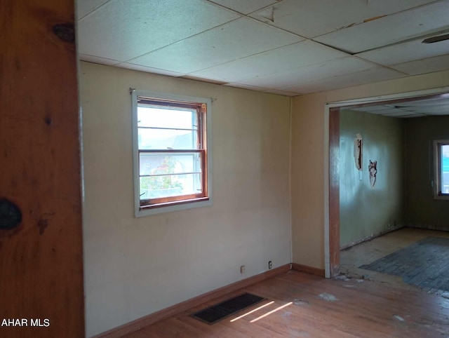 unfurnished room with a paneled ceiling and light hardwood / wood-style flooring