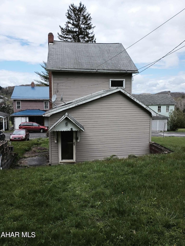 back of house featuring a lawn