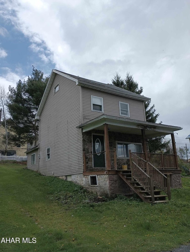 view of front of property featuring covered porch and a front lawn